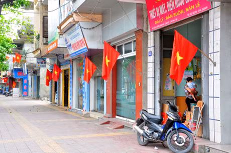 Vỉa hè thông thoáng, nhà dân treo cờ tổ quốc.