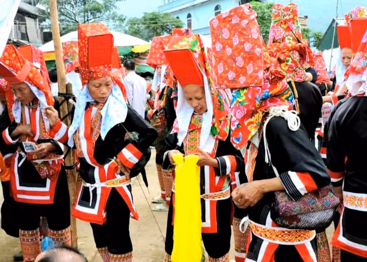 Phụ nữ dân tộc Dao chọn lựa vải, nguyên liệu may, dệt thổ cẩm ở chợ phiên Đồng Văn. Ảnh: Tạ Quân