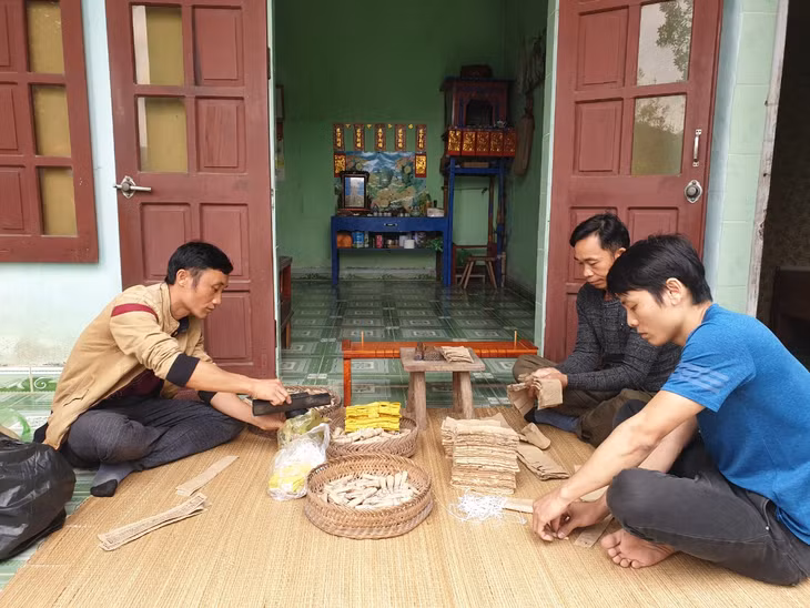 Những người đàn ông trong gia đình cùng nhau làm giấy cúng
