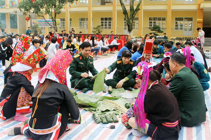 Các lực lượng tham gia gói bánh chưng tặng cho các hộ gia đình có hoàn cảnh khó khăn.