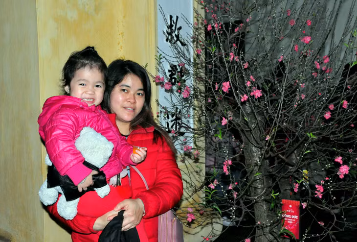 Em bé háo hức vui cười vì được theo mẹ đi lễ chùa.