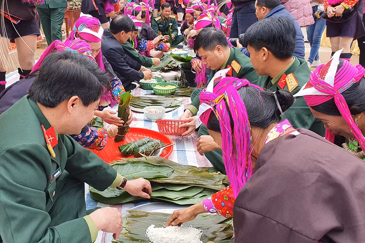 Cán bộ, chiến sĩ Ban CHQS huyện Tiên Yên phối hợp gói bánh chưng tặng cho các hộ dân Khu tái định cư bản Nà Cà.