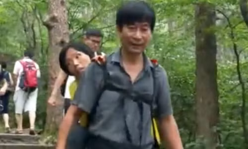 Anh Wang Xiaomin địu vợ leo núi. Ảnh: Yahoo News Singapore.