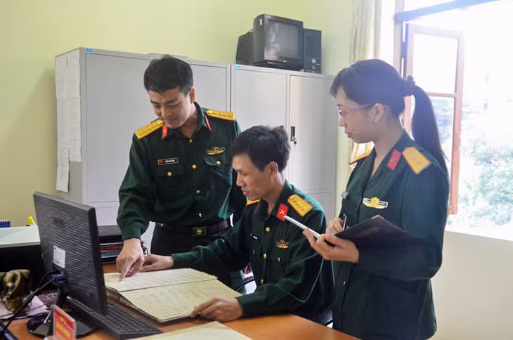 Đại úy Nguyễn Văn Lý (người ngồi) cùng các cán bộ trong Ban Chính sách Bộ CHQS tỉnh rà soát, tra cứu thông tin các liệt sĩ. Ảnh: Lưu Linh.