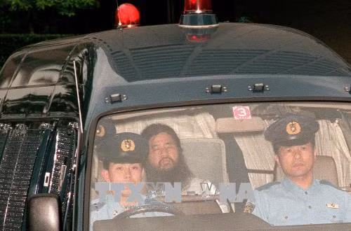 Thủ lĩnh giáo phái AUM Shinrikyo Shoko Asahara (giữa) được áp giải tới tòa án quận Tokyo tháng 7/1995. Ảnh: AFP/TTXVN