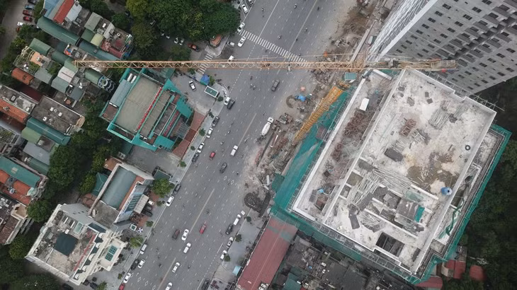 Cần cẩu bôc xếp vật liệu vươn ra ngoài đường.