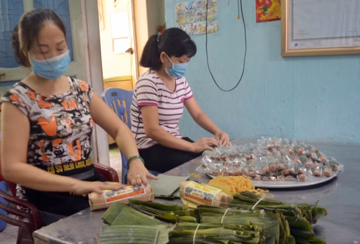 Chị Vũ Thị Thu Hương đang tỷ mỉ ngói nem chua tại cơ sở sản xuất của mình.