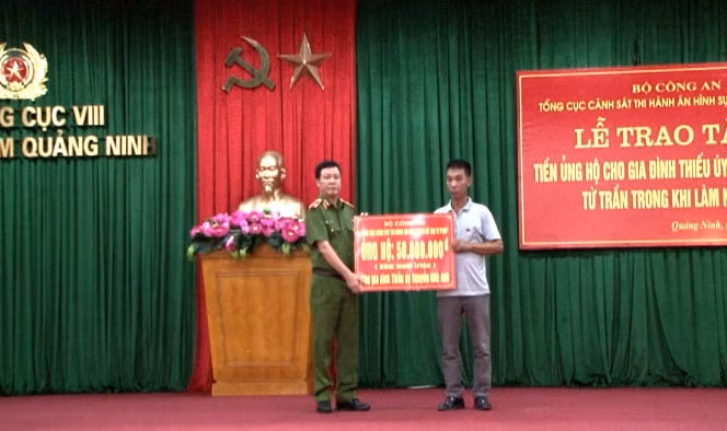 Thiếu tướng Tô Xuân Bốn, Phó tổng cục trưởng Tổng cục Thi hành án hình sự và hỗ trợ tư pháp (Bộ Công an) trao tiền hỗ trợ cho gia đình Thiếu úy Nguyễn Đức Anh (Ảnh: Quang Duy-Công an Quảng Ninh)