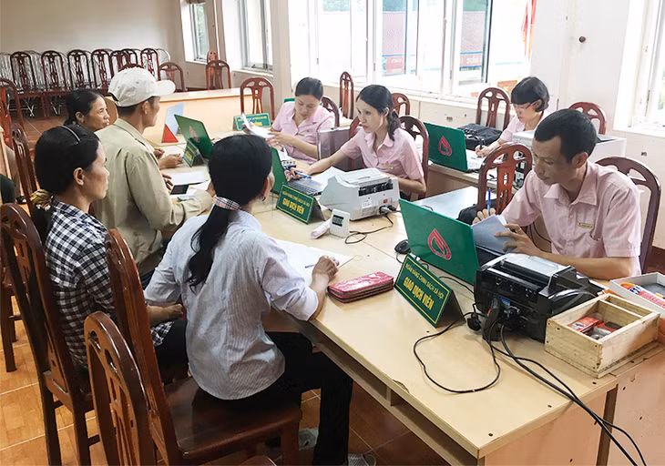 Cán bộ NHCSXH huyện Hoành Bồ thực hiện huy động tiền gửi tiết kiệm tại điểm giao dịch xã Đồng Lâm, huyện Hoành Bồ