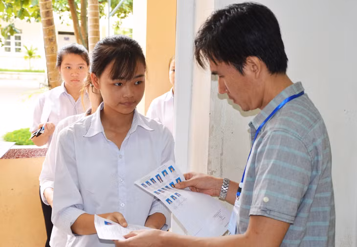 Cán bộ coi thi điểm thi THPT Hoành Bồ kiểm tra thẻ dự thi thí sinh