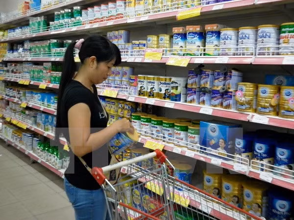 Khách hàng chọn mua sữa bình ổn giá tại Siêu thị Co.op Mart Thanh Hà. (Ảnh: Lan Phương/TTXVN)