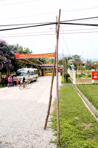 Trước cổng Trường THCS Hồng Thái Tây, nơi mà hằng ngày có hàng trăm lượt học sinh, phụ huynh qua lại, hệ thống dây điện được đỡ tạm bợ bằng những cây gỗ chống.