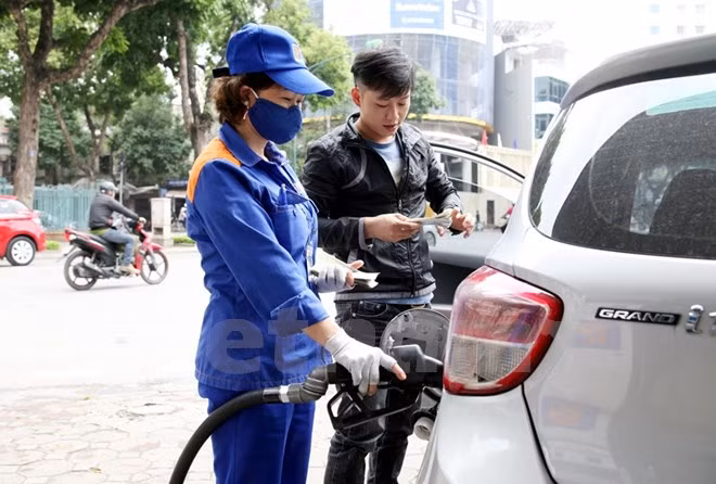 Nhân viên Petrolimex đang bán xăng cho khách hàng. (Ảnh: Doãn Đức/Vietnam+)