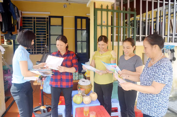 Cán bộ chuyên trách dân số phường Hà Phong (TP Hạ Long) phát tờ rơi tuyên truyền về Đề án 52 cho người dân khu 8, phường Hà Phong.