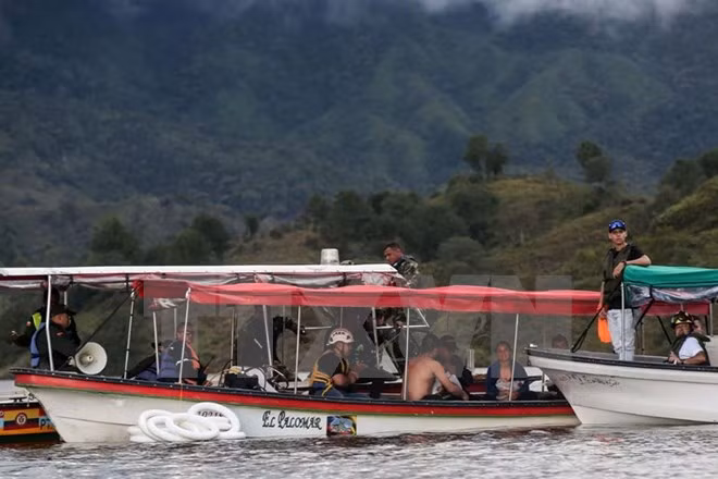Lực lượng cứu hộ tìm kiếm người mất tích sau vụ chìm tàu. (Nguồn: AFP/TTXVN)