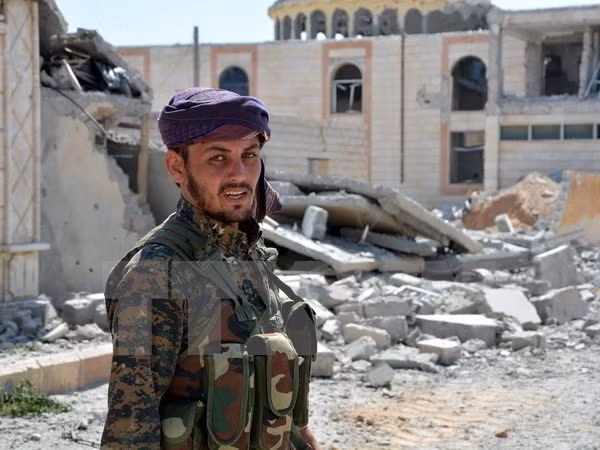 Các tay súng của YPG tuần tra tại thành phố Raqqa, Syria. (Ảnh: EPA/TTXVN)
