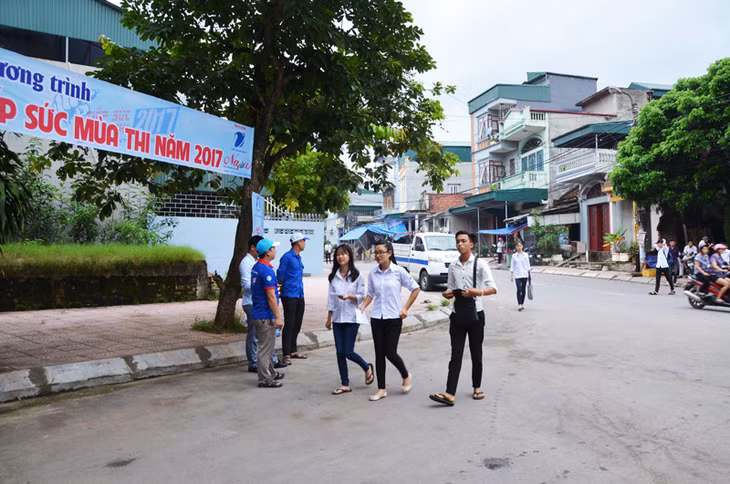 Lực lượng đoàn viên thanh niên đứng trước cổng điểm thi để hỗ trợ thí sinh
