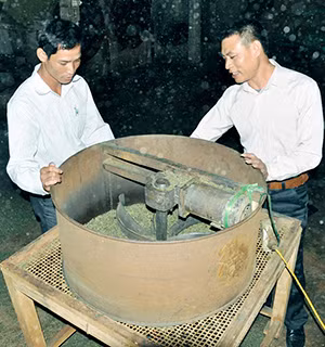 Anh Phạm Văn Khiêm (bên phải) giới thiệu về chiếc máy sàng chè.