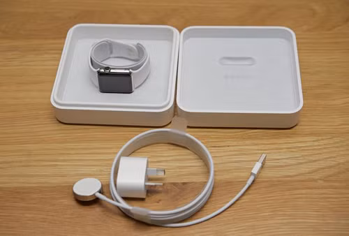Apple Watch phiên bản tiêu chuẩn với hộp vuông, mặt đế sạc bằng kim loại.