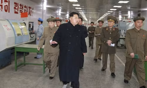 Lãnh đạo Triều Tiên Kim Jong-un (áo đen) thị sát một nhà máy sản xuất bộ phận tên lửa và thiết bị quân sự ở Bình Nhưỡng. (Ảnh: EPA)