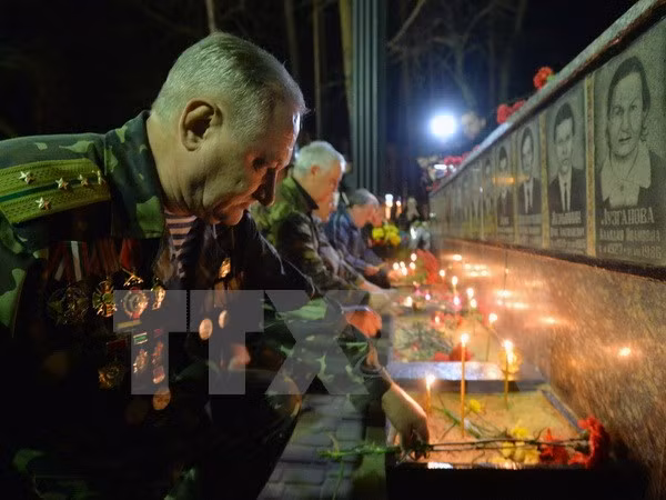 Người dân Ukraine đặt hoa tưởng niệm tại tượng đài các nạn nhân của thảm họa Chernobyl ngày 26/4 tại Slavutich, cách địa điểm xảy ra vụ tai nạn 50km. (Nguồn: AFP/TTXVN)