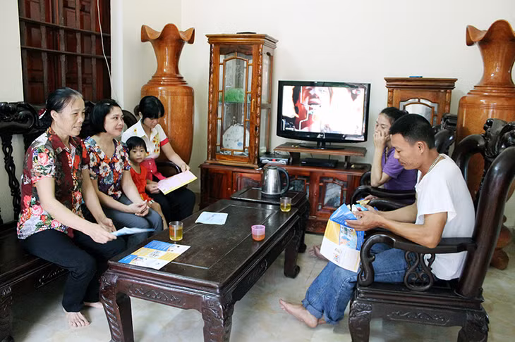 Bà Nguyễn Thị Mẫu (ngoài cùng, bên trái) đến tận nhà tuyên truyền chính sách DS-KHHGĐ cho người dân thôn 15, xã Hiệp Hoà, TX Quảng Yên.