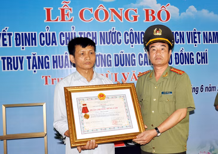 Thừa ủy quyền của Chủ tịch nước, Đại tá Nguyễn Văn Sinh, Phó Giám đốc Công an tỉnh trao Huân chương Dũng cảm cho thân nhân Trung uý Bùi Văn Bình.