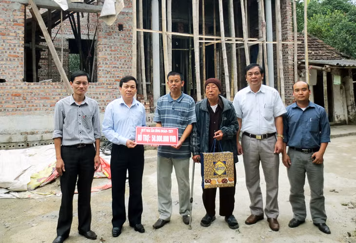 Anh Vũ Đình Việt, Chủ tịch Công đoàn Công ty CP Than Vàng Danh (thứ 2, trái sang) trao Quỹ “Mái ấm Công đoàn” cho gia đình công nhân Nguyễn Quang Điện, Phân xưởng ô tô.