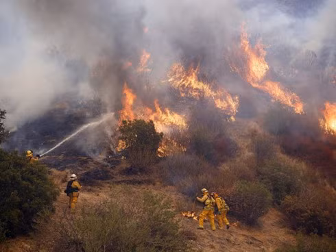 Nhân viên cứu hỏa nỗ lực dập tắt với “giặc lửa” ở Santa Clarita, California. (ảnh: EPA).