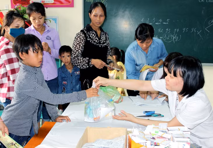 Các y, bác sĩ của CLB Thầy thuốc trẻ Quảng Ninh phát thuốc miễn phí cho người dân, trẻ em xã Hoành Mô (huyện Bình Liêu).