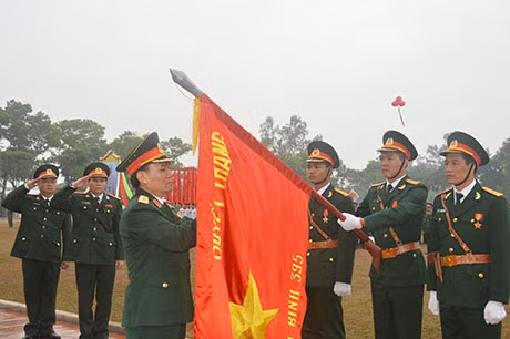 Chú thích ảnh: Trung tướng Phạm Hồng Hương, Tư lệnh Quân khu 3, gắn Huân chương Bảo vệ Tổ quốc hạng Nhất của Chủ tịch nước lên lá cờ Quyết thắng của Sư đoàn 395.(0080.jpg)