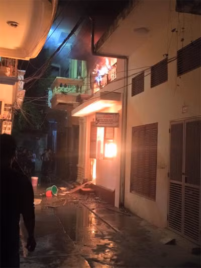 Ngôi nhà cháy nằm trong ngõ gồm nhiều nhà cao tầng sát nhau cùng đường dây điện nổi chằng chịt. Ảnh: Giang Chinh.