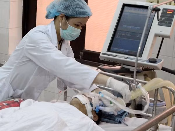 Nhân viên y tế Bệnh viện Bệnh Nhiệt đới Trung ương kiểm tra sức khỏe cho một bệnh nhân. (Ảnh: TTXVN)
