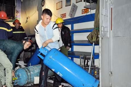Nhân viên cửa hàng khẩn trương di chuyển các bình gas khỏi hiện trường.