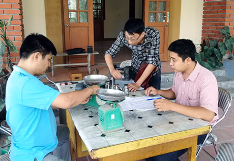 Cán bộ Chi cục Tiêu chuẩn Đo lường Chất lượng kiểm định cân của các hộ kinh doanh tại chợ Cột, thị trấn Đông Triều.