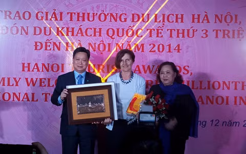 Lãnh đạo Bộ VHTTDL và UBND thành phố Hà Nội trao kỷ niệm chương và quà tặng cho vị khách thứ 3 triệu đến Hà Nội năm 2014 (ảnh: Báo Tin tức)