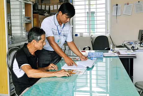CB,CC xã Hạ Long (Vân Đồn) hướng dẫn cho người dân làm thủ tục hành chính tại trụ sở xã.