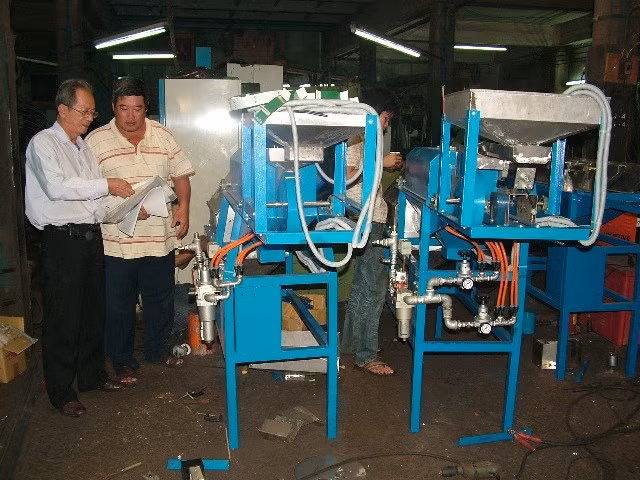 Ông Nguyễn Văn Lãng (bìa trái) tại một cơ sở chế tạo máy tách vỏ hạt điều theo công nghệ VN