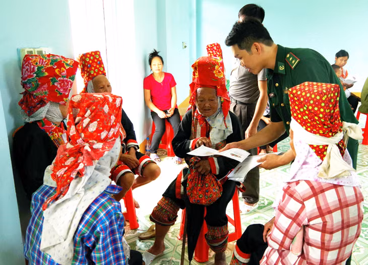 Chiến sĩ Đồn Biên phòng Quảng Đức tuyên truyền cho đồng bào Dao Thanh Phán các kiến thức về y tế. 