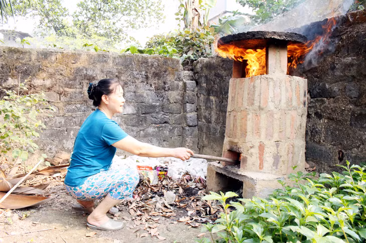 Bà Vũ Thị Châu, phường Minh Thành, TX Quảng Yên đốt rác thải sinh hoạt tại lò đốt của gia đình.