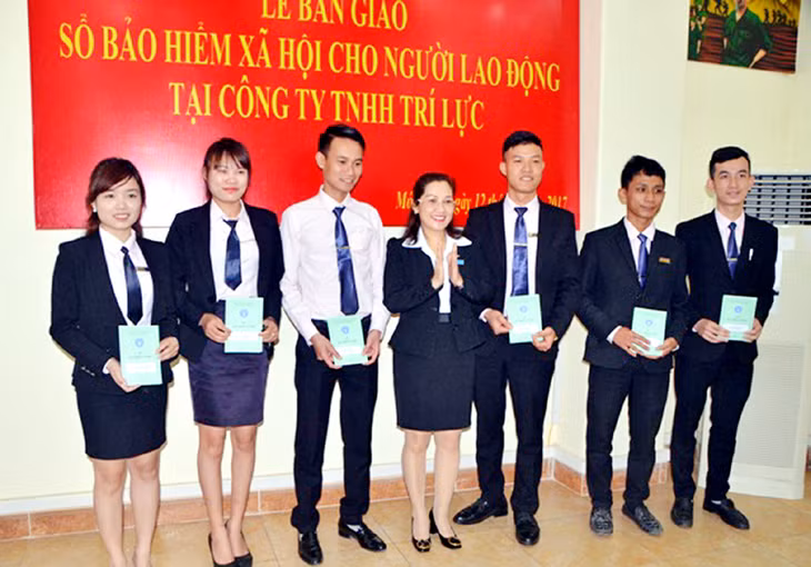 Lãnh đạo BHXH TP Móng Cái trao sổ BHXH cho người lao động tại Công ty TNHH Trí Lực, TP Móng Cái. Ảnh: Vân Thoa (BHXH tỉnh)