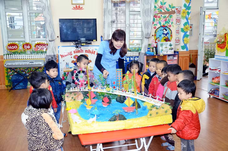 Giáo viên Trường Mầm non Hoa Hồng (TP Hạ Long) giới thiệu mô hình “Vịnh Hạ Long - cây cầu Bãi Cháy” cho trẻ lớp 4-5 tuổi. Ảnh Lan Anh