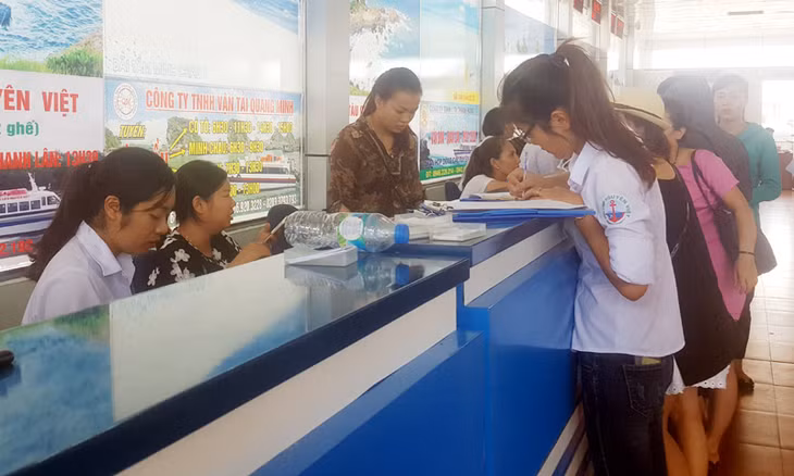 Khách du lịch mua vé đi tham quan các tuyến đảo của huyện Vân Đồn tại quầy vé của Cảng Cái Rồng.