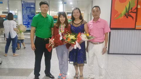 Lãnh đạo Trung tâm TDTT tặng hoa chúc mừng VĐV Phạm Thị Huệ tại sân bay Nội Bài. Ảnh: CTV 