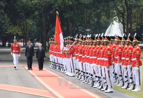 Tổng thống Indonesia Joko Widodo và Tổng Bí thư Nguyễn Phú Trọng duyệt đội danh dự tại lễ đón. Ảnh: Trí Dũng/TTXVN