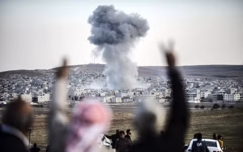 Đám đông hò reo sau một cuộc không kích của Mỹ vào IS tại Kobani (Ảnh AFP)