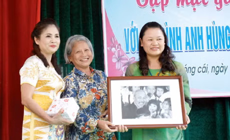 Bà Minh Vân (giữa) trao tặng 400 triệu đồng cho Quỹ khuyến học Đào Phúc Lộc và bức ảnh bà được chụp cùng Bác Hồ cho lãnh đạo nhà trường.