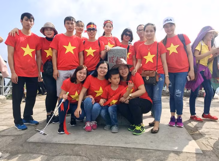 Khách du lịch đến tham quan, chụp ảnh lưu niệm bên cột mốc 1297 (Bình Liêu).