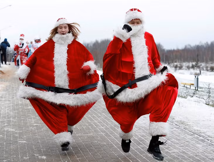 Cặp đôi mặc trang phục của Ông già Noel tham gia cuộc thi chạy Santa Run ở Minsk, Belarus. Ảnh: Reuters