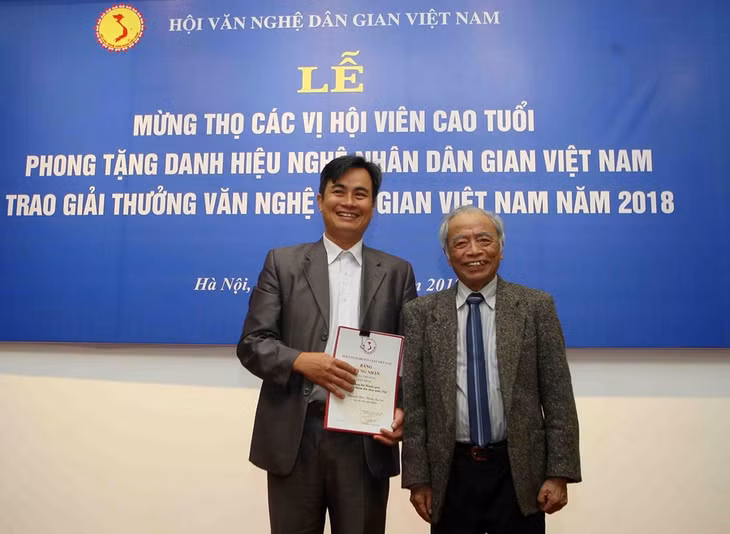 GS Tô Ngọc Thanh (phải) trao giải Nhất giải thưởng Văn nghệ dân gian 2018. Ảnh: TTXVN